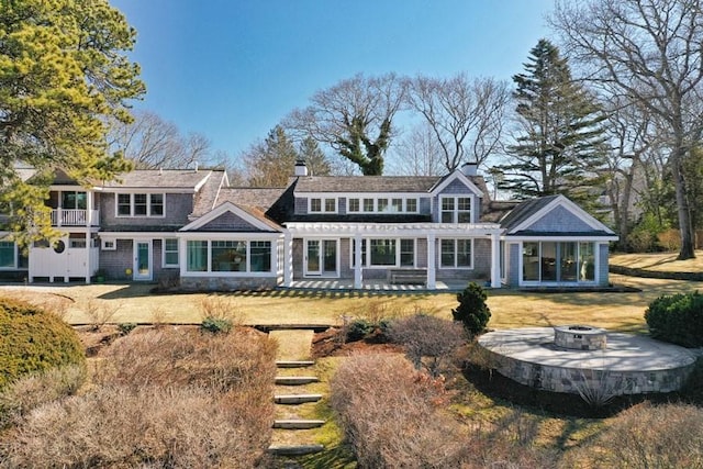 rear view of property with an outdoor fire pit, a patio area, a chimney, and a pergola