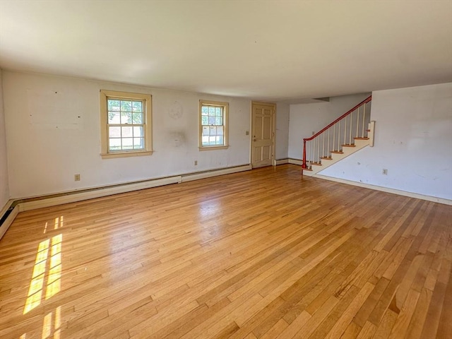 spare room with baseboard heating and light wood-type flooring