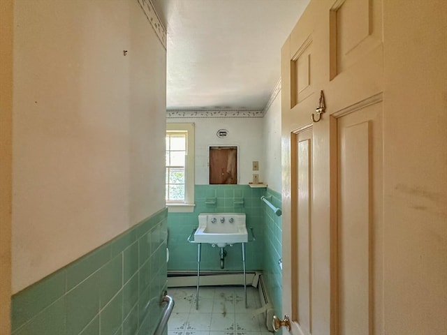 bathroom featuring sink, tile walls, and a baseboard heating unit