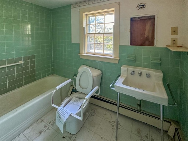 bathroom featuring toilet, sink, tile walls, a bathing tub, and a baseboard heating unit