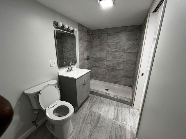 bathroom featuring tiled shower, vanity, and toilet