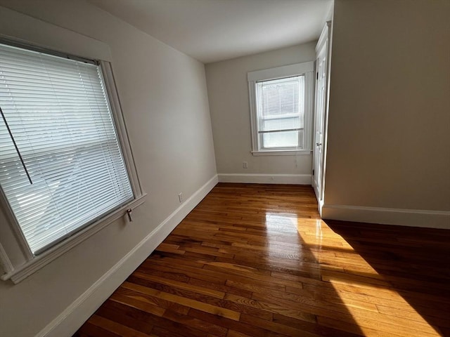 empty room with dark hardwood / wood-style flooring