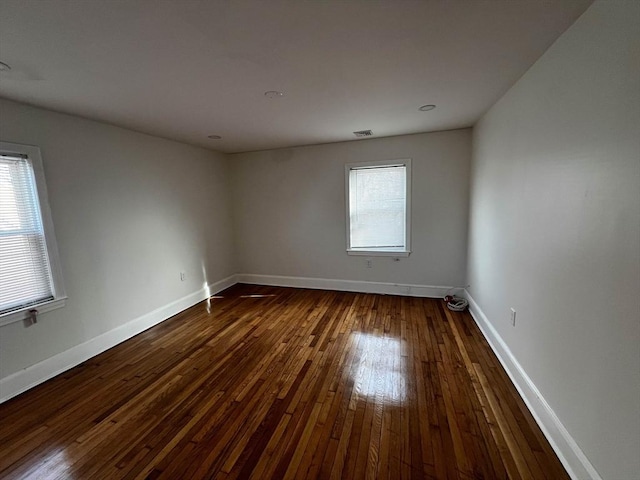 unfurnished room with a healthy amount of sunlight and wood-type flooring