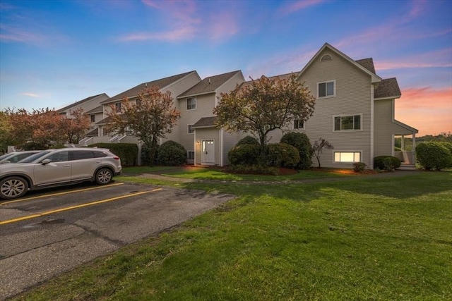 view of front of house featuring uncovered parking and a front yard