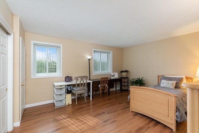 bedroom with light wood finished floors and baseboards