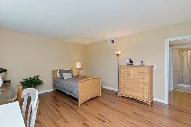 bedroom with light wood finished floors and baseboards