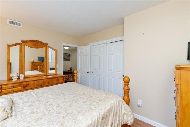 bedroom featuring a closet, baseboards, and wood finished floors