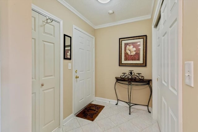 foyer entrance featuring baseboards, ornamental molding, and light tile patterned floors