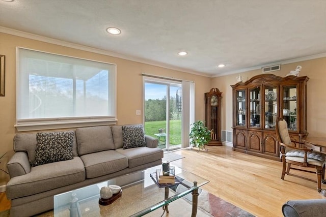 living room with wood finished floors, crown molding, and recessed lighting