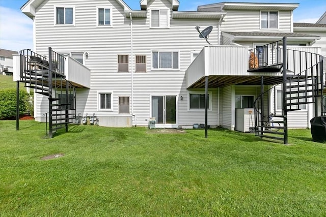 rear view of house with stairs, a lawn, and a wooden deck