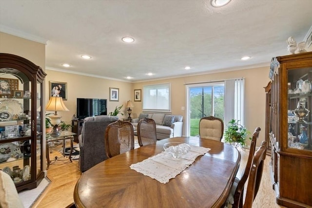 dining room featuring light wood-type flooring, recessed lighting, and crown molding
