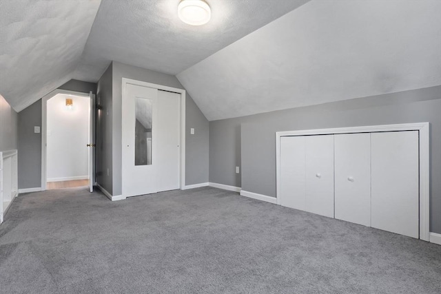 bonus room featuring lofted ceiling, carpet, and baseboards