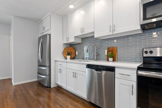 kitchen featuring stainless steel appliances, a sink, light countertops, dark wood finished floors, and white cabinets