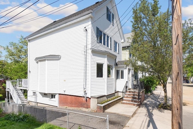 view of side of home featuring fence