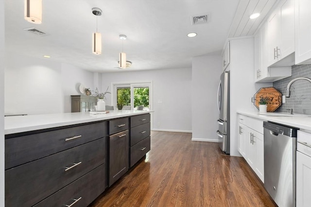 kitchen featuring stainless steel appliances, a sink, white cabinets, light countertops, and recessed lighting