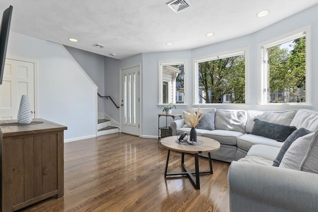 living room featuring dark wood finished floors, stairs, baseboards, and recessed lighting