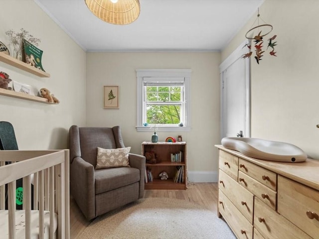 49 Fern Rd, Medford, MA 02155 - bedroom with a crib, light wood-style floors, crown molding, baseboards, and a desk