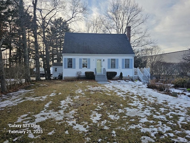 new england style home featuring a shingled roof and a chimney