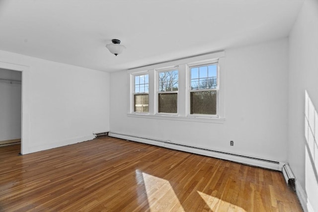 1210 Highland St, Holliston, MA 01746 - unfurnished bedroom featuring a baseboard heating unit and wood finished floors