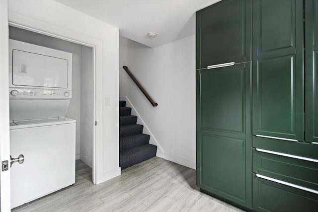 9 Cedar St Unit 1, Boston, MA 02119 - washroom with estacked washer and dryer, light wood-style flooring, and baseboards