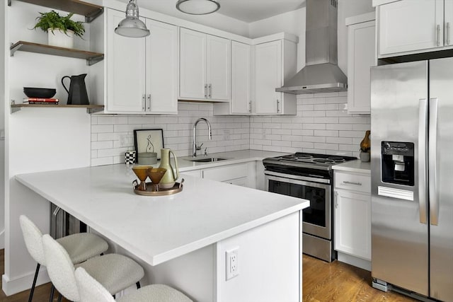 9 Cedar St Unit 1, Boston, MA 02119 - kitchen featuring stainless steel appliances, wall chimney exhaust hood, a sink, open shelves, and a peninsula