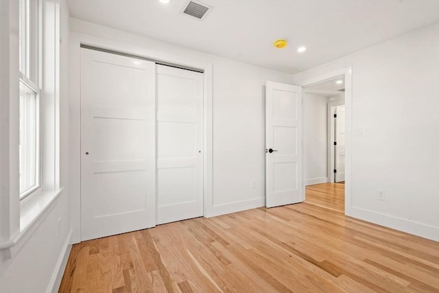 unfurnished bedroom featuring a closet and light hardwood / wood-style flooring