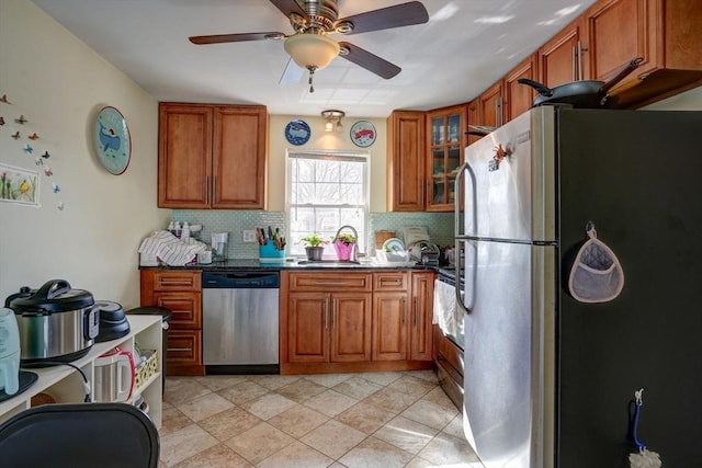 kitchen with dark stone counters, backsplash, appliances with stainless steel finishes, and ceiling fan