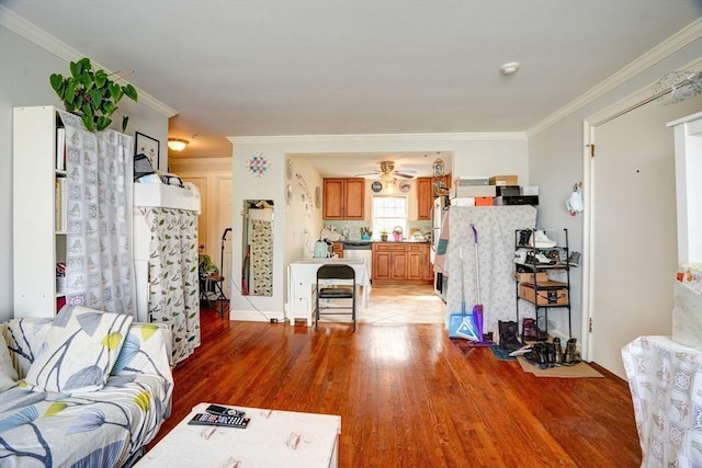 living room featuring crown molding, ceiling fan, and light hardwood / wood-style flooring