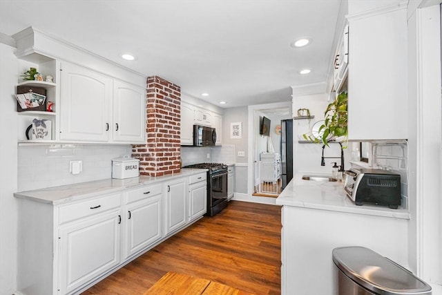 kitchen featuring white cabinetry, a sink, black appliances, and open shelves