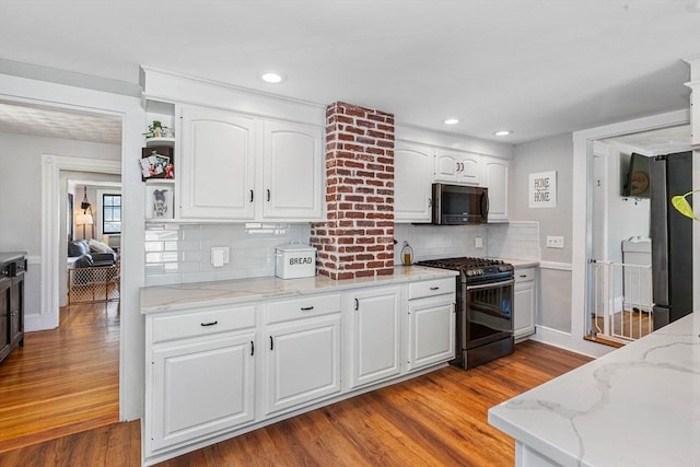 kitchen with white cabinetry, stainless steel microwave, black gas stove, and open shelves