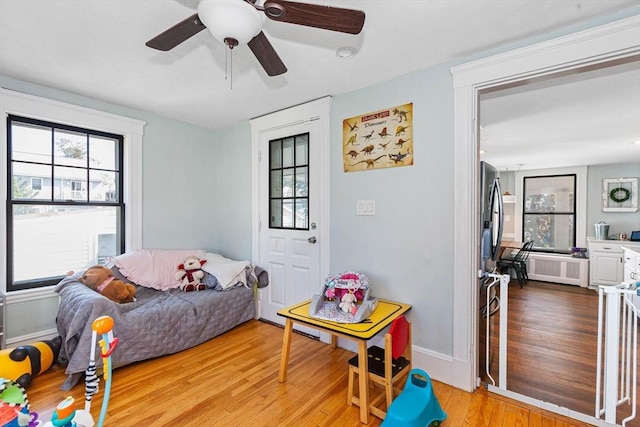 interior space with ceiling fan, light wood finished floors, and baseboards