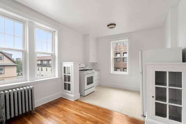 97 Chester St Unit 8, Boston, MA 02134 - kitchen featuring white range with gas stovetop, radiator, and light wood-style floors