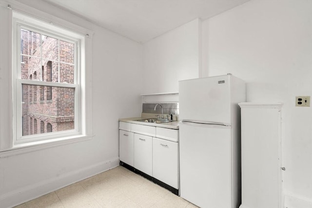 97 Chester St Unit 8, Boston, MA 02134 - kitchen with freestanding refrigerator, light flooring, white cabinets, and light countertops