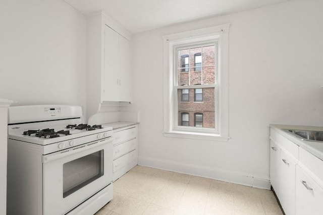 97 Chester St Unit 8, Boston, MA 02134 - kitchen with gas range gas stove, white cabinetry, light flooring, and light countertops