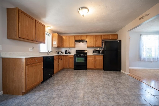 2 Garden St, Uxbridge, MA 01569 - kitchen featuring black appliances, under cabinet range hood, light countertops, baseboards, and a sink