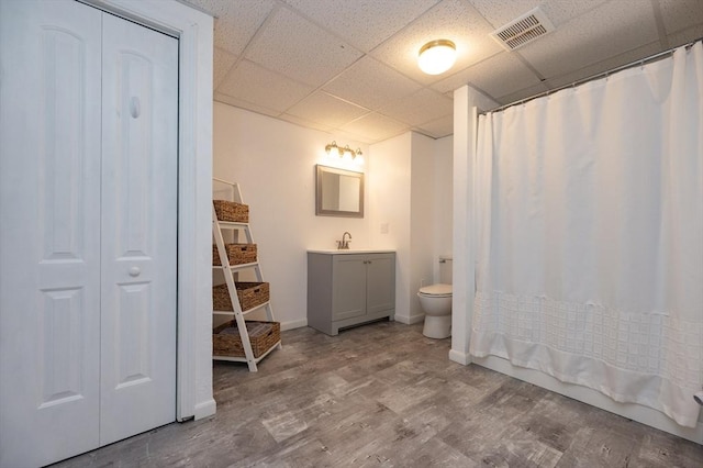 2 Garden St, Uxbridge, MA 01569 - bathroom with vanity, a drop ceiling, toilet, wood finished floors, and a closet