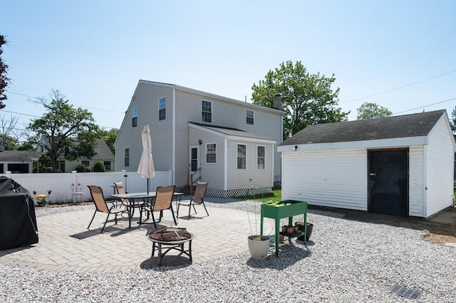 2 Garden St, Uxbridge, MA 01569 - back of property featuring a fire pit, a patio, an outbuilding, and a garage