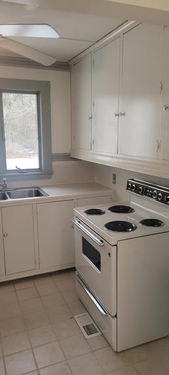 kitchen with white cabinetry, sink, and white range with electric cooktop