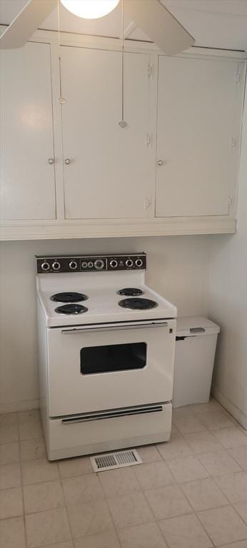 kitchen with white electric stove and white cabinets