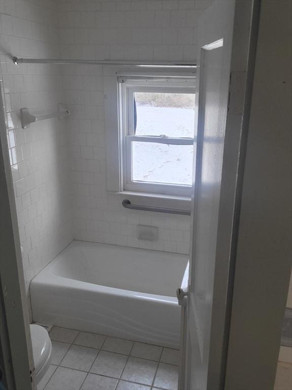 bathroom featuring tile patterned floors, toilet, and tiled shower / bath combo