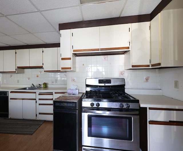 kitchen with decorative backsplash, light countertops, a sink, stainless steel gas range, and dark wood-type flooring