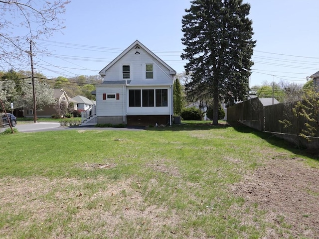 back of house with fence and a yard