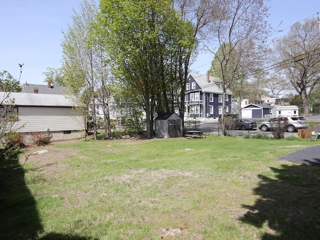 view of yard with a storage shed, an outdoor structure, and a residential view