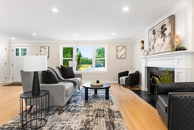 586 Lowell St, Peabody, MA 01960 - living area with crown molding, wood finished floors, a fireplace with flush hearth, and recessed lighting
