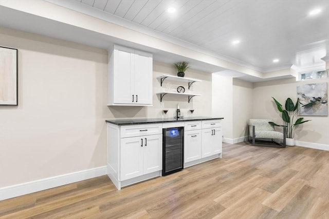 586 Lowell St, Peabody, MA 01960 - kitchen featuring open shelves, wine cooler, dark countertops, light wood-style floors, and white cabinets