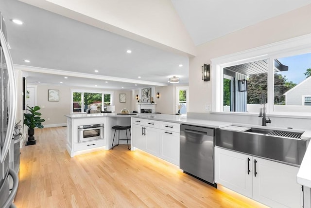 586 Lowell St, Peabody, MA 01960 - kitchen featuring stainless steel appliances, a peninsula, open floor plan, plenty of natural light, and recessed lighting