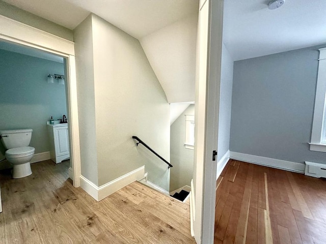 staircase featuring baseboards and wood finished floors