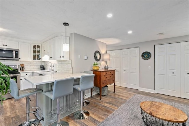 kitchen featuring white cabinets, sink, appliances with stainless steel finishes, tasteful backsplash, and dark hardwood / wood-style flooring