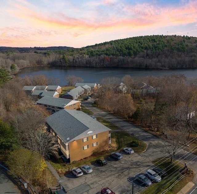 aerial view at dusk featuring a water view