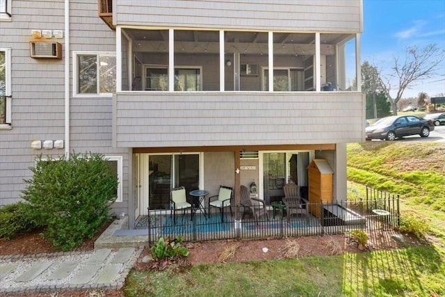 back of house featuring an AC wall unit, a patio area, and a sunroom